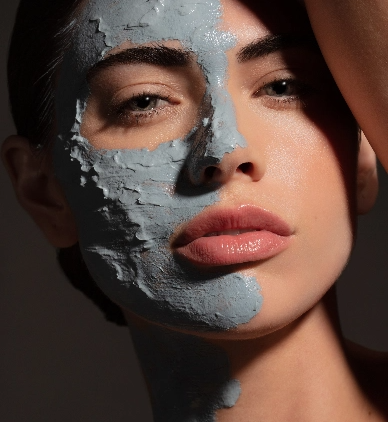 a woman with half of her face covered in skin care products